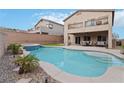 Backyard oasis featuring a sparkling pool, jacuzzi, covered patio, and lush greenery for outdoor enjoyment at 176 Dunblane St, Henderson, NV 89012