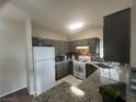 Modern kitchen with granite countertops, stainless steel appliances, and dark cabinetry at 1830 N Buffalo Dr # 2021, Las Vegas, NV 89128