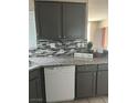 Modern kitchen with gray cabinets, granite countertops, and a stylish tile backsplash at 1830 N Buffalo Dr # 2021, Las Vegas, NV 89128