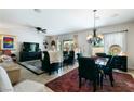 Open concept dining area with a stylish chandelier, tile floors, and adjacent living space at 2188 Cumberland Hill Dr, Henderson, NV 89052