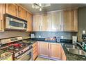Well-lit kitchen featuring stainless steel appliances, granite countertops, and wooden cabinets at 220 E Flamingo Rd # 317, Las Vegas, NV 89169