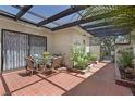 Enclosed patio area with a glass table, chairs, tile flooring, and gated entryway at 2558 La Fortuna Ave, Las Vegas, NV 89121