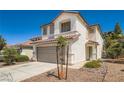 Two story home features a desert landscape, tile roof, and a two car garage at 3141 Diamond Crest Ln, Henderson, NV 89052