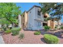 Two story condo building with stucco exterior, desert landscaping, mature trees and shrubs at 3151 Soaring Gulls Dr # 2050, Las Vegas, NV 89128