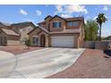 Exterior view of a two-story home with a long driveway and neutral tones in a desert landscape at 5228 Giallo Vista Ct, North Las Vegas, NV 89031