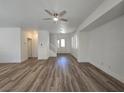 Bright living room with ceiling fan, wood-look floors and neutral paint at 6638 Babys Tear Pl, Las Vegas, NV 89148
