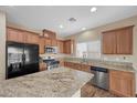 Beautiful kitchen featuring wood cabinets, stainless steel appliances and granite countertops at 7028 Weavers Pl, North Las Vegas, NV 89084