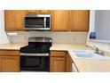 Functional kitchen with stainless steel appliances, wooden cabinets, and ample counter space for meal preparation at 7163 S Durango Dr # 113, Las Vegas, NV 89113