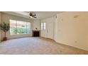 Bright living room with large windows, neutral carpet, and a cozy fireplace, perfect for relaxing and entertaining at 7163 S Durango Dr # 113, Las Vegas, NV 89113