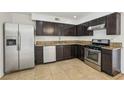 The kitchen is equipped with stainless steel appliances, granite countertops and dark wood cabinets at 882 Westminster Ave, Las Vegas, NV 89119