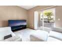 Cozy living room with plush white furniture and a sliding glass door to the outside at 9330 W Maule Ave # 138, Las Vegas, NV 89148