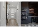 Elegant hallway leads to a stylish bar area with a mini-fridge and floating shelves at 9617 Sard Ln, Las Vegas, NV 89143