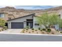 Modern home with a flat roof, two-car garage, desert landscaping, and mountain views at 9789 Twilight Moon Ave, Las Vegas, NV 89148
