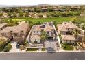 Expansive aerial view of a home and neighborhood featuring a golf course and mountain views at 11453 Glowing Sunset Ln, Las Vegas, NV 89135