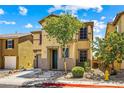 Two-story home featuring tan stucco, a tile roof, a well-manicured lawn, and an attached garage at 11894 Snow Bank St, Las Vegas, NV 89183