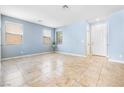 Bright, open living room featuring neutral walls, large windows, and stylish tile flooring at 11894 Snow Bank St, Las Vegas, NV 89183