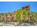 Beautiful building exterior showing elegant landscaping and tall palm trees under a bright sunny sky at 15 Via Mantova # 302, Henderson, NV 89011