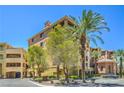 Lovely building exterior showcasing beautiful landscaping with tall palm trees under a bright blue sky at 15 Via Mantova # 302, Henderson, NV 89011