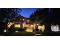 Charming two-story home with beautifully landscaped front yard and walkway leading to gated entrance at night at 16 Mallard Creek Trl, Henderson, NV 89052