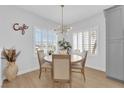 Cozy dining area with modern lighting fixture, plantation shutters, and a round wood table for four at 2279 Keego Harbor St, Henderson, NV 89052