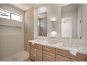 Bathroom featuring double sinks, quartz countertops, and a walk-in shower at 2561 Terrytown Ave, Henderson, NV 89052