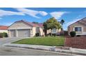 Beautiful single-story home boasts a well-maintained lawn and mature landscaping at 2707 Gardenia Flower Ave, North Las Vegas, NV 89031