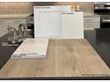 Beautiful interior materials feature white cabinets, a brushed nickel faucet, and vinyl plank flooring at 3871 Riley Rose Ave, Las Vegas, NV 89139
