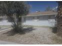 Cozy home exterior featuring a well-maintained yard and mature trees, with a glimpse of the roof at 4329 Studio St, Las Vegas, NV 89115