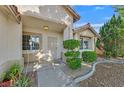 Welcoming front entrance with a security door, manicured shrubs, and desert landscaping at 4624 Windy Hollow St, Las Vegas, NV 89130