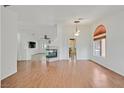 Open-concept living room with laminate floors, fireplace, and lots of light at 4624 Windy Hollow St, Las Vegas, NV 89130