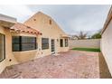 Backyard area featuring a brick patio, stucco wall, and desert landscaping at 5151 Tennis Ct, Las Vegas, NV 89120