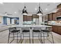 Well-lit kitchen with granite countertops, stainless steel appliances, and breakfast bar at 5801 Exbury Gardens Ct, Las Vegas, NV 89118