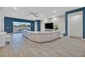 Modern living room with a large sectional sofa and sliding doors leading to backyard at 5801 Exbury Gardens Ct, Las Vegas, NV 89118