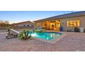 Backyard pool and spa with stone surround and ample patio space for entertaining at 5801 Exbury Gardens Ct, Las Vegas, NV 89118