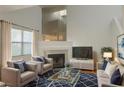 Bright living room with a fireplace, a high ceiling, and comfortable seating on a patterned blue rug at 6250 W Flamingo Rd # 88, Las Vegas, NV 89103