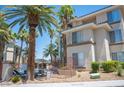 Condominium building featuring manicured landscaping, palm trees and neutral color scheme, offering a welcoming and well-maintained facade at 7155 S Durango Dr # 205, Las Vegas, NV 89113