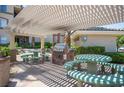 Community outdoor grilling area featuring a built-in grill, covered pergola, and picnic tables at 7155 S Durango Dr # 205, Las Vegas, NV 89113