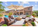 Beautiful backyard featuring a pool, a fire pit, ample seating, and an outdoor kitchen at 7794 River Mist Ct, Las Vegas, NV 89113