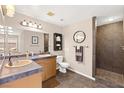 Bathroom featuring a double vanity, framed mirror, a water closet, and a tiled shower at 7794 River Mist Ct, Las Vegas, NV 89113