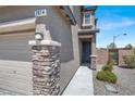 Close up of the front door with decorative stone accents and a well-lit entryway at 7814 Granite City Ct, Las Vegas, NV 89166