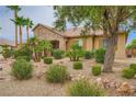Well-landscaped front yard with desert plants and mature trees surrounding a single-story home at 8032 Audubon Canyon St, Las Vegas, NV 89131
