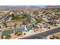 Wide aerial view of a neighborhood with single-Gathering homes and tree-lined streets, mountains in background at 813 Cherry Dr, Henderson, NV 89002