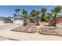 Well maintained single Gathering home with lush, mature palms in decorative rock beds at 813 Cherry Dr, Henderson, NV 89002