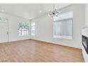 Bright living room with large windows, modern light fixture, light wood floors, and sleek fireplace at 831 Purple Sage Ter, Henderson, NV 89015