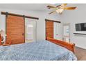 Main bedroom features unique barn doors and a ceiling fan at 930 High Plains Dr, Henderson, NV 89002