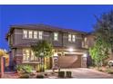 Two-story home with a well-manicured front yard and a two-car garage, captured at dusk at 10243 Aragon Crown Rd, Las Vegas, NV 89135