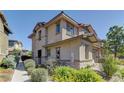 Stylish two-story house features low-maintenance landscaping, a stone facade, and a welcoming walkway at 10360 Pescado Ln, Las Vegas, NV 89135