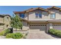 Charming two-story home boasts a two-car garage, brick driveway, and well-maintained landscaping at 10360 Pescado Ln, Las Vegas, NV 89135