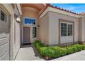 Inviting front entrance features a manicured garden, front door with sidelights, and exterior lighting at 2102 Rhonda Ter, Henderson, NV 89074