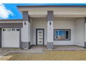 Charming home featuring a modern front door, three-car garage, and manicured landscaping at 2110 S Manzanita Dr, Pahrump, NV 89048